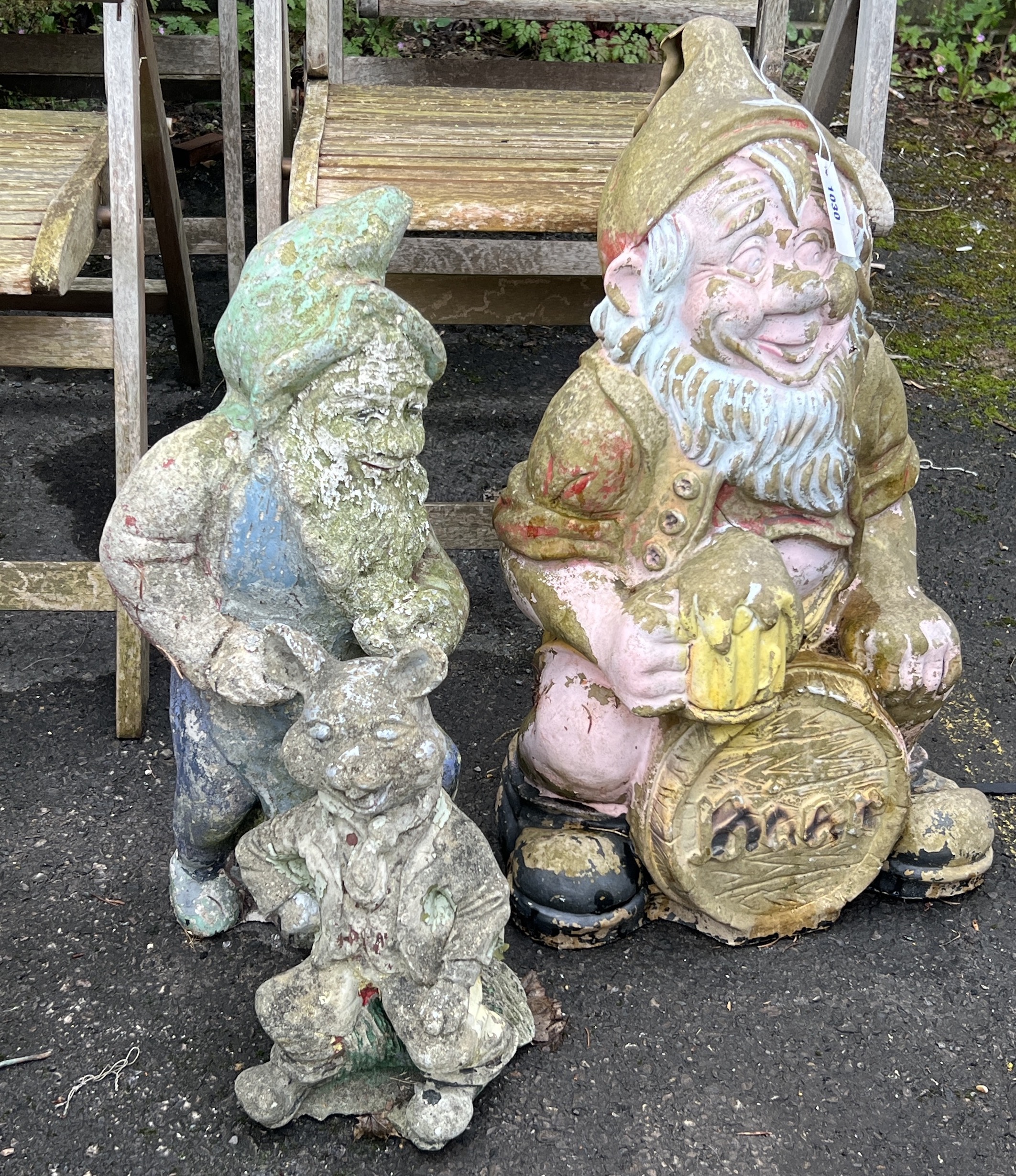 Two reconstituted stone and fibreglass gnome garden ornaments, larger height 65cm together with a seated pig garden ornament